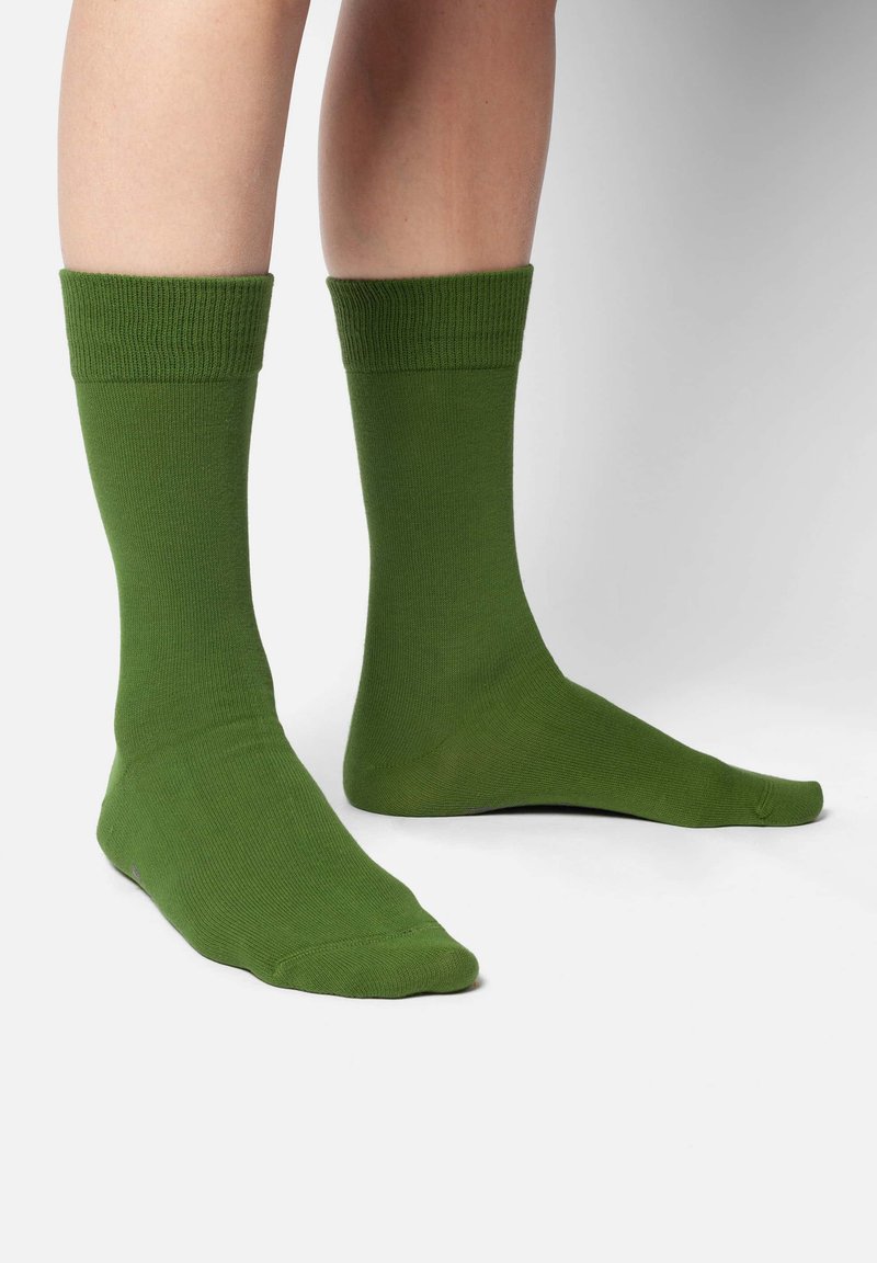 Grüne Baumwollsocken mit einem gerippten Bund, glatter Textur und mittellanger Länge. Entworfen für Komfort und Langlebigkeit.