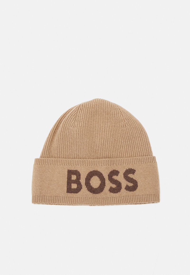 Pletená čepice v odstínu tan s lemem, na kterém je tkaný nápis "BOSS" v hnědé barvě. Měkká textura, žebrovaný vzor a zaoblený vrchol.