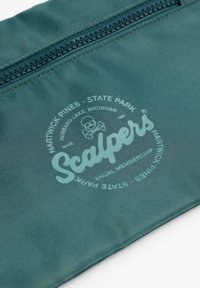 Bolsa de nailon verde con cierre de cremallera. Logo impreso con "Scalpers" y "Hartwick Pines State Park" rodea una ilustración de una calavera.