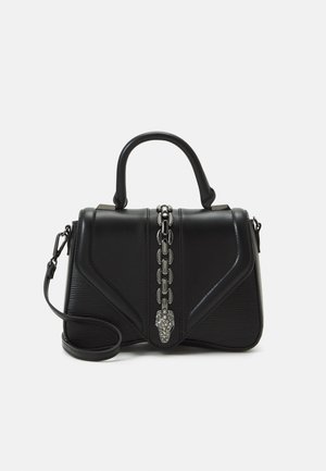 Sort struktureret håndtaske med topstrop, aftagelig skulderrem og central sølvkædedetalje, der ender i en dekorativ lås.