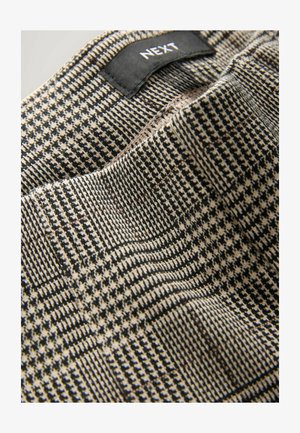 Tessuto intrecciato con un motivo a quadri black e beige. Presenta una cucitura interna visibile e un'etichetta con il marchio "NEXT" nella parte superiore.
