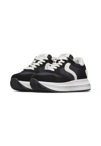 Sneaker bianco e nero realizzati in suede e pelle, con punta rotonda, lacci bianchi, logo a contrasto e una spessa suola bianca.