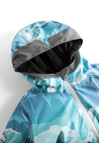 Chaqueta con capucha de un patrón abstracto azul y turquesa, con acentos grises y un suave forro de felpa negra. Presenta un cierre frontal.