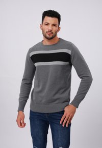 Gray knitted sweater featuring horizontal stripes in black and light gray, with a crew neck and ribbed cuffs and hem.