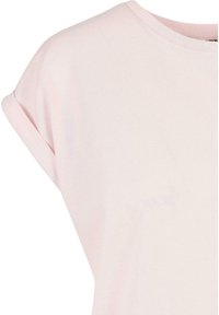 Světle růžový krátký rukáv top vyrobený z měkké bavlny. Má kulatý výstřih a ohrnuté rukávy. Hladký povrch, minimalistický design.