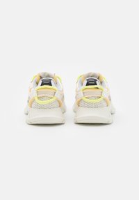 Lightweight running shoes featuring a white mesh upper with yellow accents, gray overlays, and a textured sole for traction.