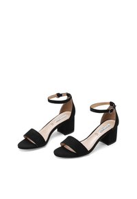 Sandali neri in suede con tacco a blocco, caratterizzati da una cintura alla caviglia e design open toe. Fodera interna liscia con uno stile minimalista.