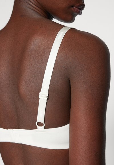 Soutien-gorge blanc avec bretelles ajustables portant en imprimé subtil le nom de la marque "BOSS". Tissu lisse au design sobre et fermeture par crochet.