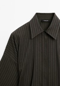 Dark, pinstriped shirt featuring a pointed collar and a button-up design, displayed against a white background.