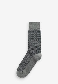 Graue Socke mit einem Fischgrätenmuster, einem einfarbigen grauen Bündchen, weicher Textur und einer schmal zulaufenden Form für einen engen Sitz.
