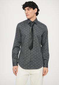 Czarna wzorzysta koszula z długim rękawem o dopasowanym kroju, z subtelnym geometrycznym wzorem, uzupełniona czarnym krawatem.