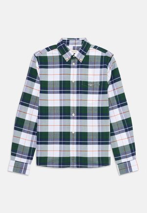Chemise à carreaux verte, bleue et blanche avec des accents orange. Manches longues, col boutonné et une poche poitrine avec détail de logo.