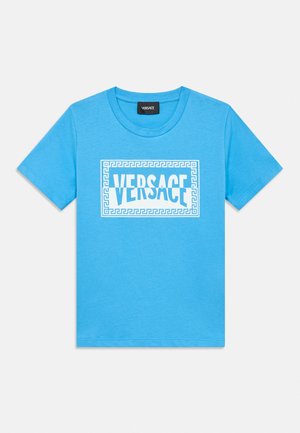 Plava majica kratkih rukava s bijelim Versace logotipom u sredini, unutar okvira s grčkim ključem na prednjoj strani.