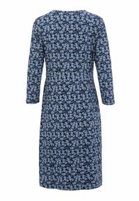 Marineblaue Knielänge Kleid mit langen Ärmeln, das ein durchgehendes hellblaues Blumenmuster zeigt, von hinten betrachtet.