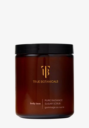 Braunes Glasgefäß mit einem schwarzen Deckel, das ein goldenes Logo und den Produktnamen zeigt. Das Etikett trägt die Aufschrift "Pure Radiance Sugar Scrub" in klarer Schrift.