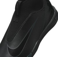 Chaussure de sport noire avec un design épuré, un dessus texturé avec un motif à côtes et une semelle en caoutchouc flexible.