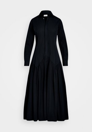 Vestido negro de manga larga con cuello abotonado, que presenta un corsé ajustado y una falda con ensamblado. Hecho de una tela suave con una textura sutil.