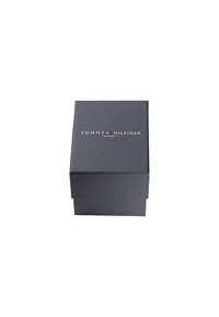 Boîte rectangulaire noire avec une fermeture magnétique, arborant le logo "TOMMY HILFIGER" en blanc et rouge sur le dessus.
