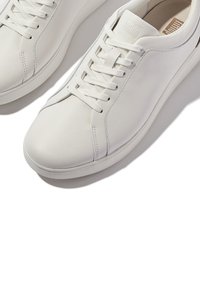 Weiße Leder-Sneaker mit glatter Textur, runder Zehenpartie und Schnürdesign. Ausgestattet mit dezenten Nähten und einem Logo auf der Zunge.