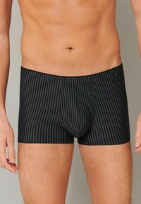 Black striped boxer briefs featuring a snug fit and elastic waistband, made from a soft textile with a smooth texture.