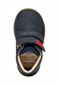 Niebieskie zamszowe buty dziecięce z rzepem, beżową podszewką i czerwonym akcentem. Okrągły czubek i gumowa podeszwa z wytłoczonym logo wewnątrz.