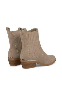 Beżowe zamszowe botki za kostkę z zaokrąglonym noskiem, żebrowanym panelem, srebrnymi nitami po bokach i niskim, odkładanym obcasem.
