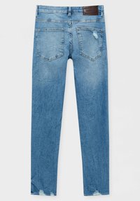 Jean en denim bleu clair avec poches arrière, légère usure sur une poche et près de l'ourlet, et une étiquette de marque en cuir marron sur la ceinture.