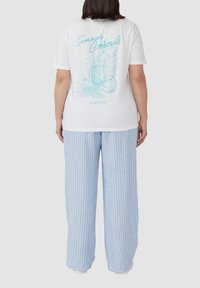 Witte katoen t-shirt met een turkooise grafiek van een cocktail op de achterkant, gecombineerd met lichtblauwe en witte gestreepte wijde broek.