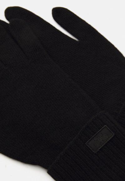 Guanti neri a maglia con polsino a costine, caratterizzati da un piccolo etichetta nera. Texture morbida con finitura liscia e design minimalista.