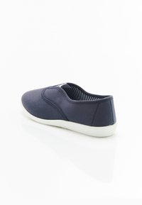 Scarpa slip-on blu navy con esterno in tela, suola in gomma bianca, punta arrotondata e fodera in tessuto a righe. Design a profilo basso.