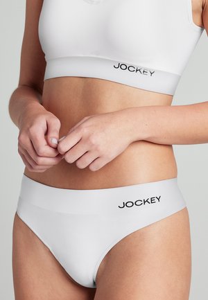 Reggiseno bianco senza cuciture e mutande a vita alta con logo JOCKEY. Texture liscia e design aderente, ideali per comfort e minima visibilità sotto i vestiti.