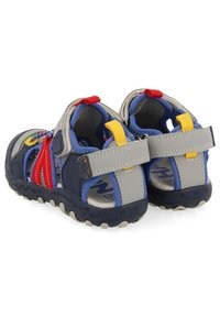 Sandalias cerradas para niños con parte superior sintética en gris y oscuro, acentos rojos y amarillos, correas ajustables, malla transpirable y suela de goma.