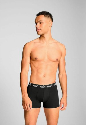 Black boxer briefs made of soft fabric with a snug fit. Features a waistband with white Puma logo. Simple design and solid color.