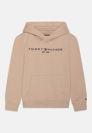 Beżowa bluza z kapturem Tommy Hilfiger z kieszenią z przodu, logo tekstowym i flagą, zakończona ściągaczami przy mankietach i kapturem, rozłożona na białym tle.