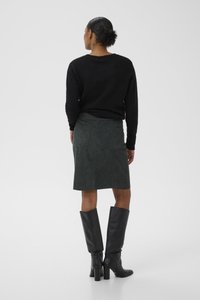 Black knit sweater, green suede skirt, knee-high black leather boots with block heels. Skirt has two back pockets. Smooth texture throughout.