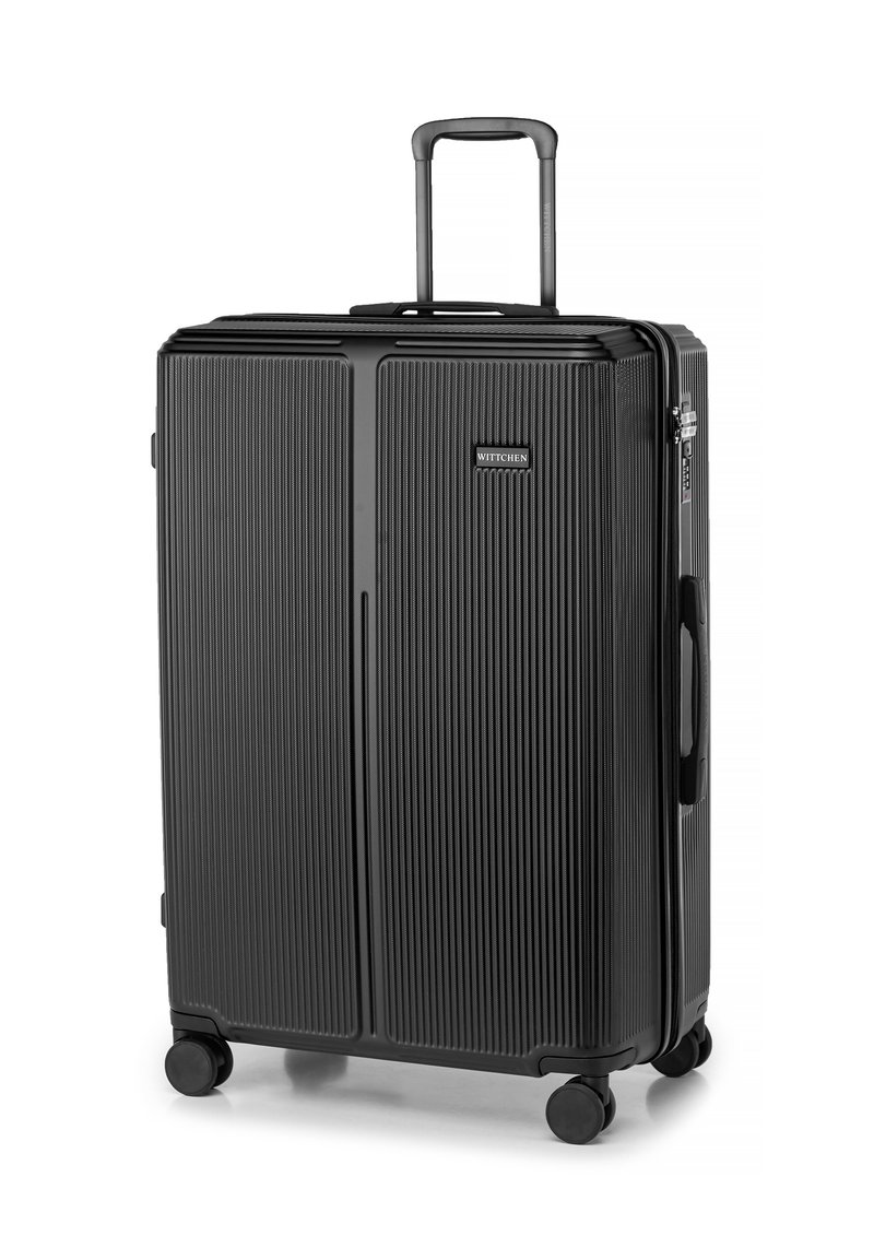 Valise rigide noire avec une texture à rainures verticales, poignée rétractable, quatre roues et un logo de marque à l'avant.