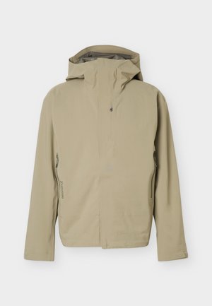 Veste beige à capuche avec zip frontal et poches latérales zippées, conçue pour une utilisation en extérieur.