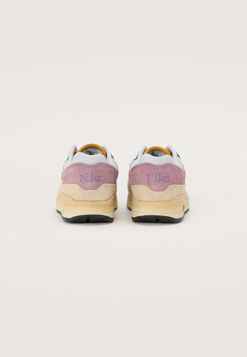 Nike sneakers met een twee-kleurig ontwerp in lichtgrijs en mauve suede. De zool is beige; logo in mauve op de hiel geperst.