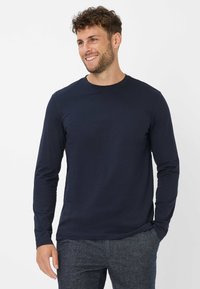 Marineblaues Langarm-T-Shirt mit Rundhalsausschnitt, aus weicher Baumwolle, mit figurbetontem Schnitt und ohne sichtbare Logos oder Muster.