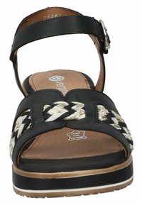 Sandale en cuir noir avec une bride en textile tressé noir et blanc, bout ouvert, sangle de cheville réglable et semelle de plateforme de couleur claire.