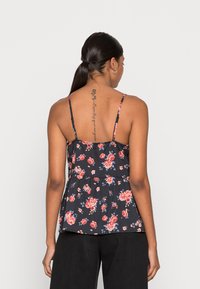 Top peplum floral com fundo preto, flores rosa e azuis, alças finas e um corpete ajustado que se estende até uma barra larga.