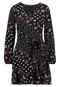 Vestito nero con maniche lunghe, decorato con pois bianchi e un motivo floreale in rosso e verde. Include un orlo arricciato e una cintura in vita.