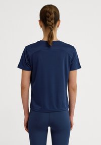 Granatowa koszulka sportowa z krótkim rękawem, uszyta z gładkiego materiału, z okrągłym dekoltem i minimalistycznym wzorem, z solidnym wykończeniem i bez widocznych logotypów.