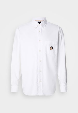 Weißes Langarm-Hemd mit Knöpfen und Knopfkragen, Fronttasche mit einem kleinen bestickten braunen und schwarzen "B"-Logo.