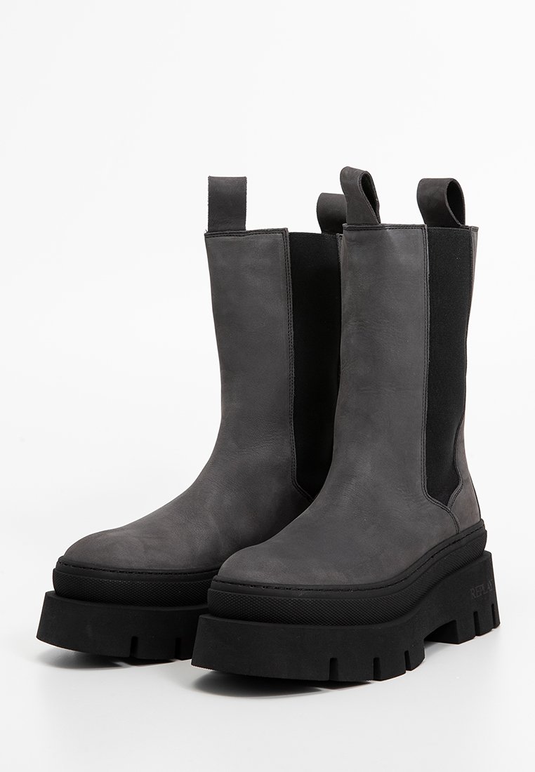 Fleischige graue Lederstiefeletten mit flachen Gummisohlen, elastischen Seiteneinsätzen und Schlaufen für ein einfaches An- und Ausziehen. Dicke Sohlen verleihen Höhe.