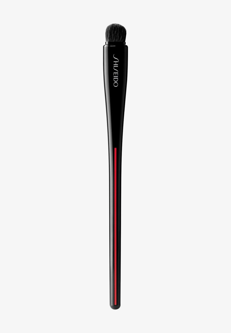 Pennello trucco Shiseido con lungo manico nero, striscia accentuata rossa e una testina morbida e arrotondata per un'applicazione precisa.