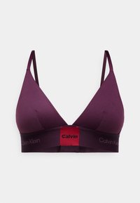 Sutien wireless violet cu un design în formă de V, bretele ajustabile și o bandă elastică lată cu un patch roșu logo. Textură netedă pe întreaga suprafață.