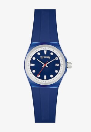 Vilebrequin zilgā silikona pulksteņi ar astoņstūrainu korpusu, tumši zilu ciparnīcu, sudraba akcentiem, baltajiem stundu rādītājiem un sarkano sekunžu rādītāju. Datuma rādītājs 3 stundās.