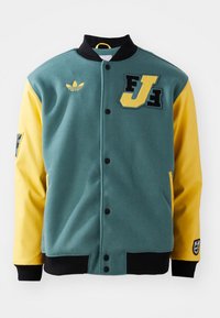 Green and yellow varsity jacket with black collar and cuffs, front snap buttons, Adidas logo, and FJ patch on the chest.
