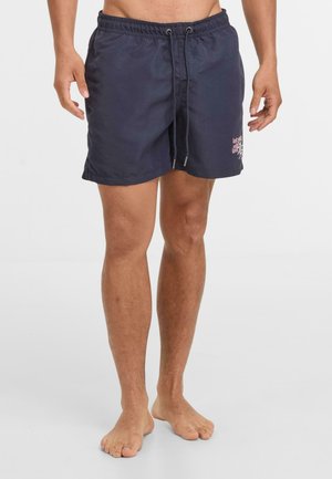 Marineblaue Badehose aus leichtem Stoff, mit elastischem Bund, Kordelzug und kleinem pinken Logo an der Seite.